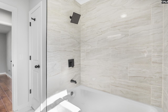 bathroom featuring shower / tub combination, baseboards, and wood finished floors