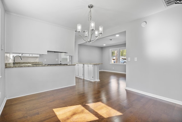 interior space with visible vents, a sink, dark wood finished floors, an inviting chandelier, and baseboards