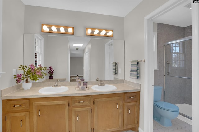 bathroom with double vanity, toilet, a stall shower, and a sink