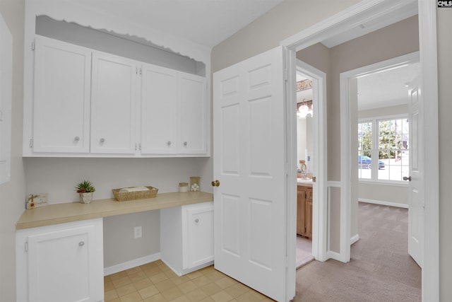 washroom featuring baseboards and light carpet