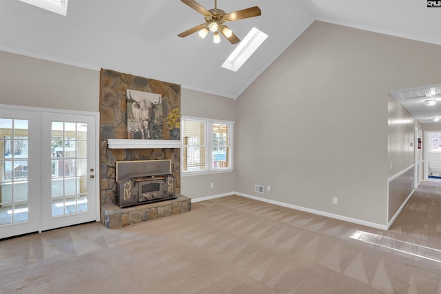 carpeted living room featuring visible vents, baseboards, ceiling fan, a skylight, and high vaulted ceiling