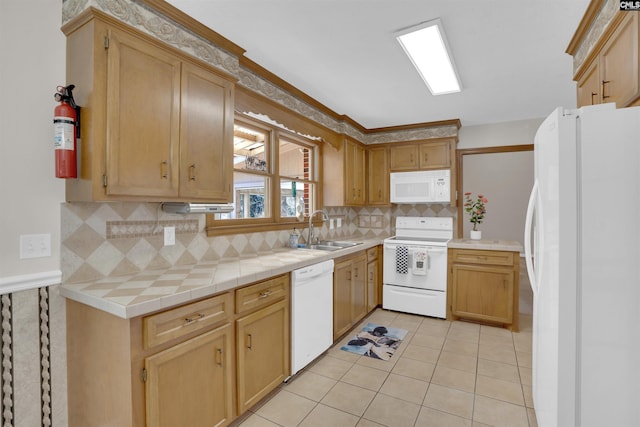 kitchen featuring light tile patterned floors, decorative backsplash, white appliances, and a sink