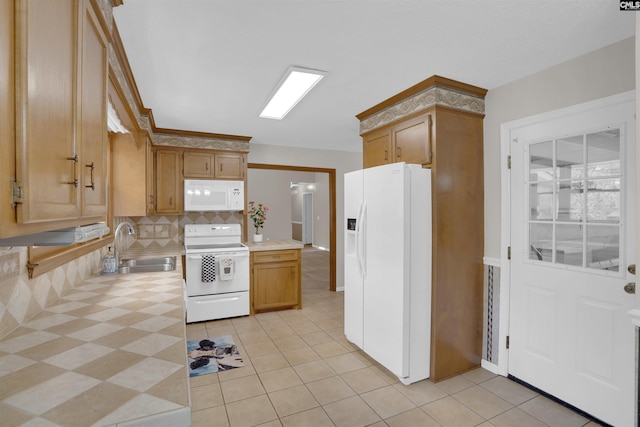 kitchen with light tile patterned floors, backsplash, white appliances, and a sink