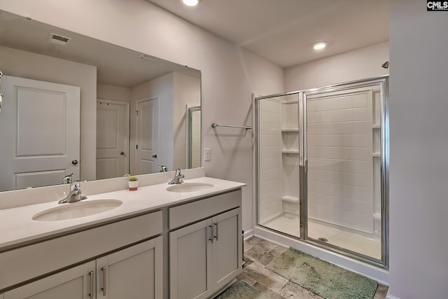 full bath featuring a sink, a stall shower, and double vanity