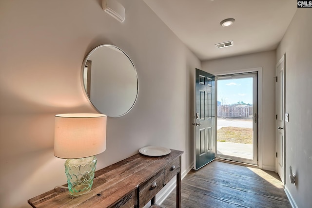 foyer entrance with wood finished floors, visible vents, and baseboards