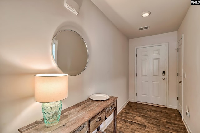 doorway featuring dark wood finished floors, visible vents, and baseboards