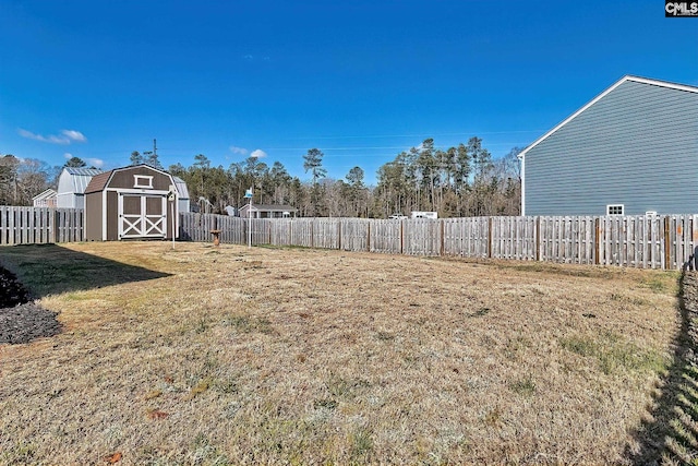 view of yard with an outdoor structure, a storage unit, and a fenced backyard