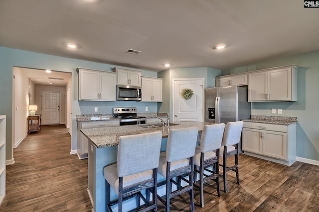 kitchen with dark wood finished floors, visible vents, appliances with stainless steel finishes, and a sink