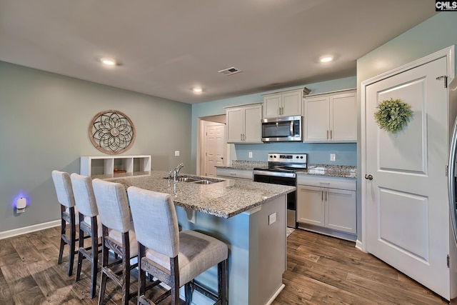 kitchen with dark wood-style floors, visible vents, stainless steel appliances, and a sink