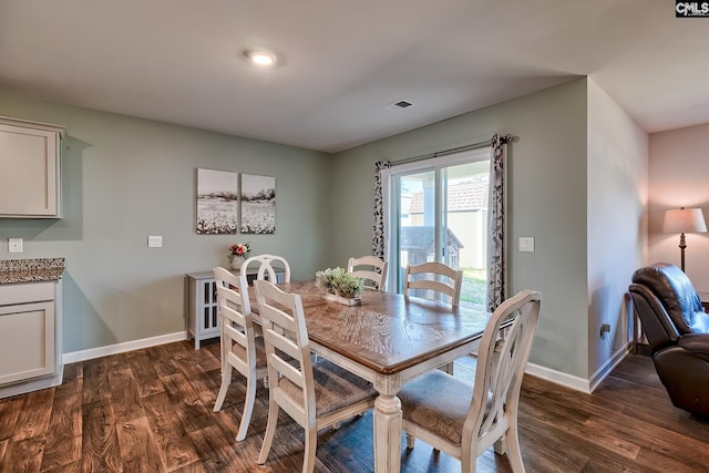 dining room with dark wood finished floors, visible vents, and baseboards