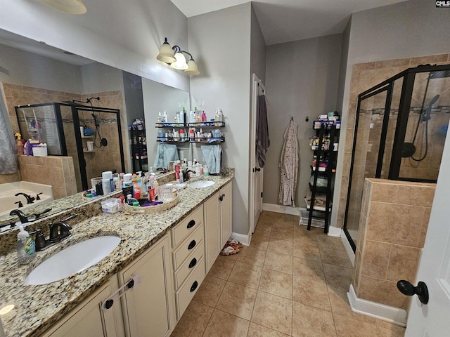 full bathroom featuring tile patterned flooring, a stall shower, double vanity, and a sink