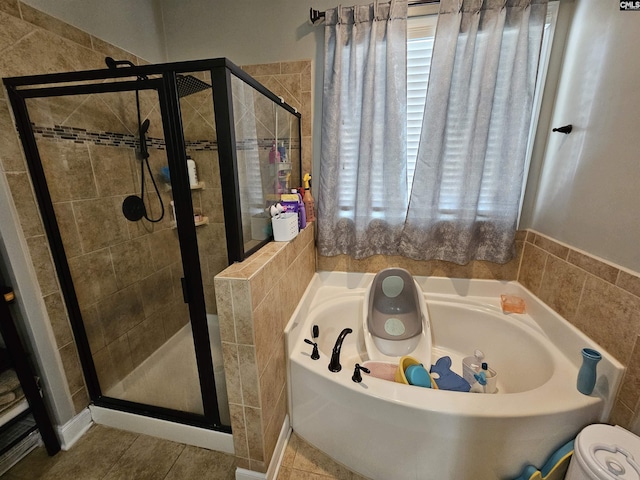 full bathroom with tile patterned flooring, a garden tub, and a stall shower