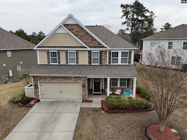 view of front of home featuring a porch, concrete driveway, an attached garage, and a shingled roof