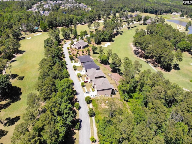 birds eye view of property with view of golf course and a water view