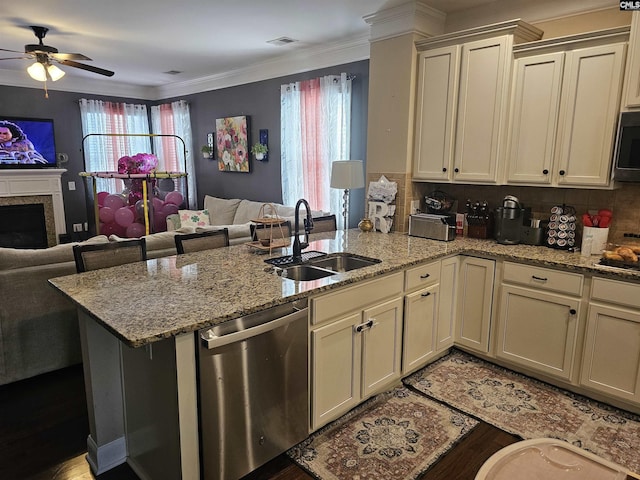 kitchen with a peninsula, a sink, ornamental molding, stainless steel appliances, and open floor plan