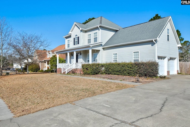 traditional-style home featuring a garage, roof with shingles, a porch, and driveway