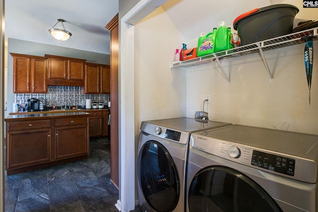 washroom featuring a sink, washing machine and dryer, and laundry area