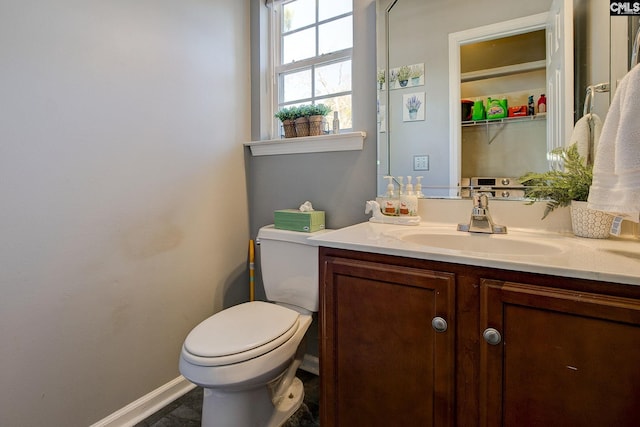 bathroom featuring vanity, toilet, and baseboards