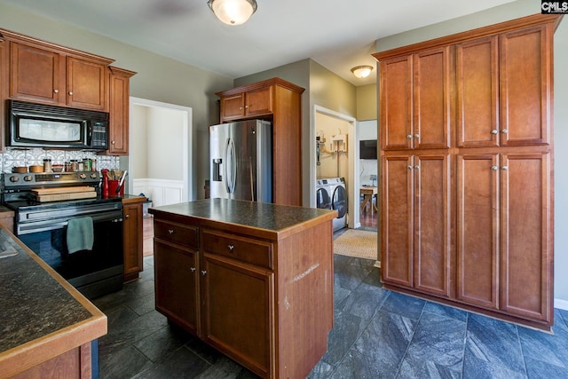 kitchen with range with electric cooktop, stainless steel fridge, black microwave, dark countertops, and independent washer and dryer