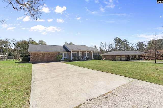 ranch-style home with brick siding, concrete driveway, and a front lawn