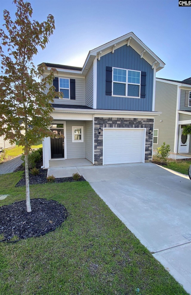 view of front facade featuring a front yard, an attached garage, concrete driveway, stone siding, and board and batten siding