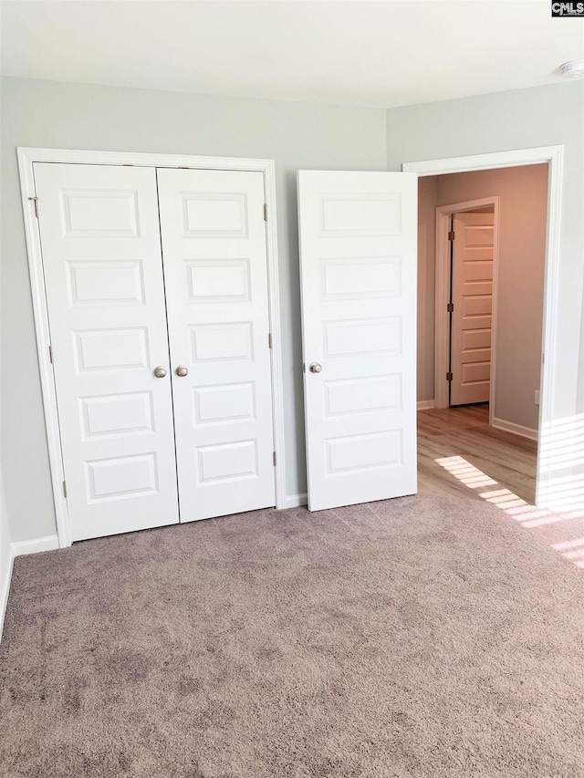 unfurnished bedroom with a closet, baseboards, and carpet