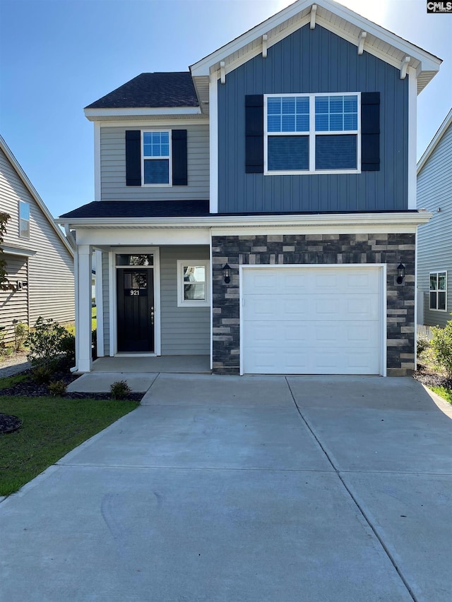 view of front facade featuring stone siding, board and batten siding, concrete driveway, and an attached garage