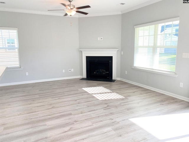 unfurnished living room with visible vents, wood finished floors, ornamental molding, and a fireplace with flush hearth