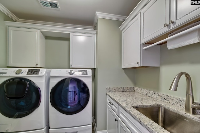 laundry area featuring visible vents, cabinet space, a sink, crown molding, and washer and clothes dryer