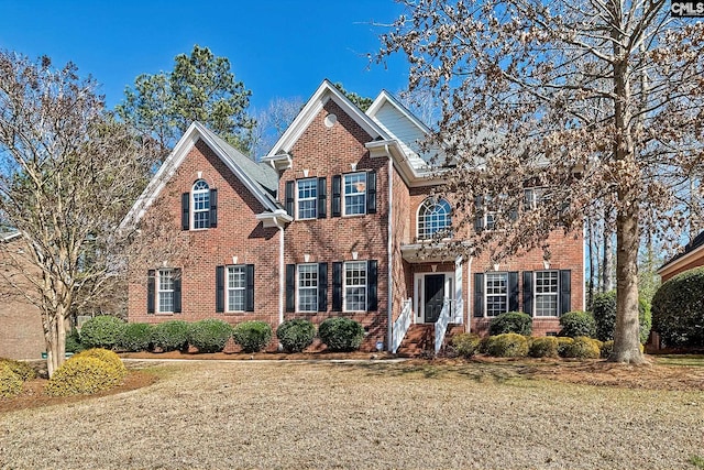 view of front of home featuring brick siding and a front yard