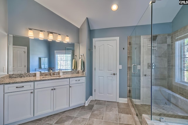 bathroom with baseboards, lofted ceiling, vanity, and a shower stall