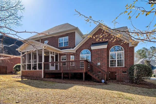 rear view of property with stairway, a lawn, brick siding, and a sunroom