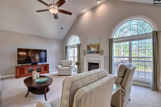 living area featuring high vaulted ceiling, light colored carpet, ceiling fan, and a fireplace