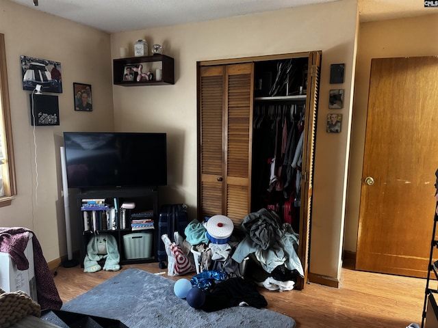 bedroom with a closet, baseboards, and wood finished floors