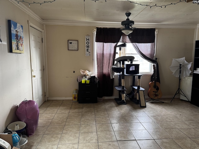 interior space featuring crown molding, light tile patterned floors, a ceiling fan, and baseboards