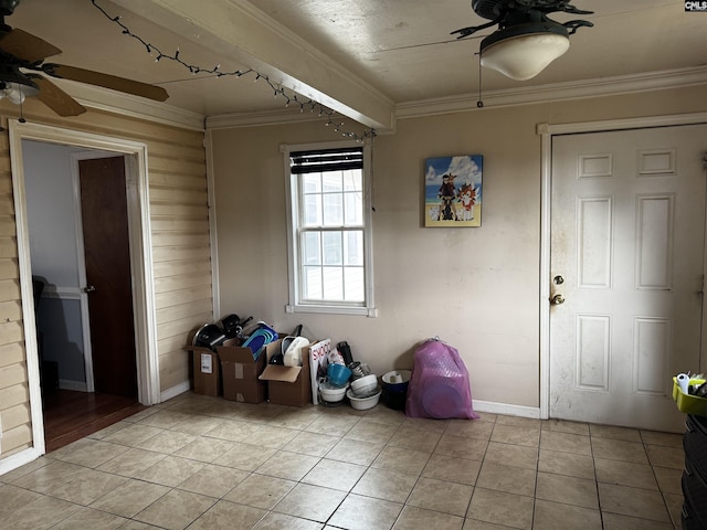 interior space featuring ornamental molding, light tile patterned flooring, baseboards, and ceiling fan