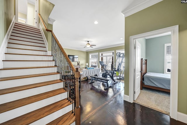 staircase with concrete floors, ceiling fan, baseboards, ornamental molding, and recessed lighting