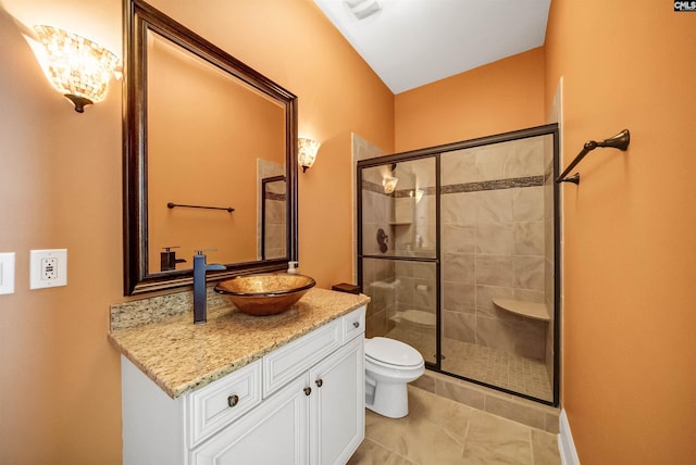 bathroom featuring tile patterned flooring, a stall shower, toilet, and vanity