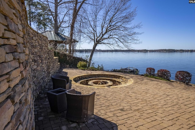 view of patio featuring a water view and an outdoor fire pit