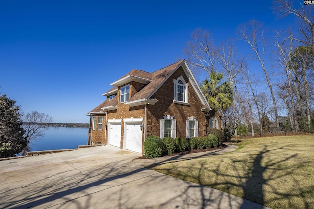 view of front of property with brick siding, fence, concrete driveway, a front yard, and an attached garage