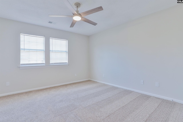 empty room with visible vents, baseboards, carpet, and ceiling fan