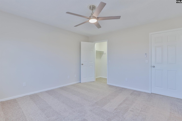 carpeted empty room featuring baseboards and a ceiling fan