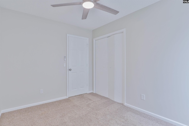 carpeted empty room with baseboards and a ceiling fan