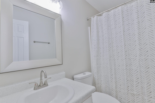 bathroom with curtained shower, toilet, and vanity