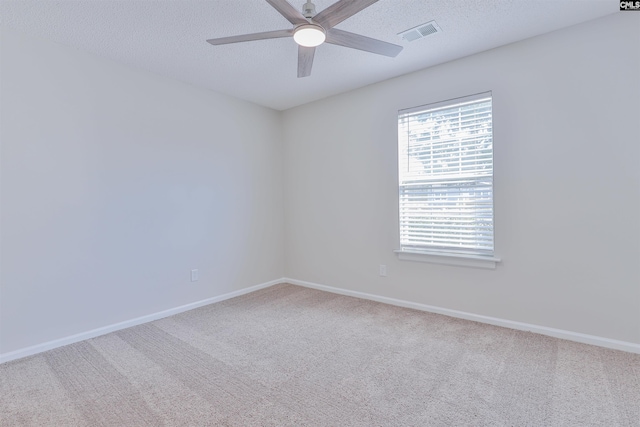 carpeted spare room with baseboards, visible vents, a textured ceiling, and ceiling fan