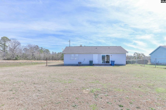 back of house featuring a yard and fence