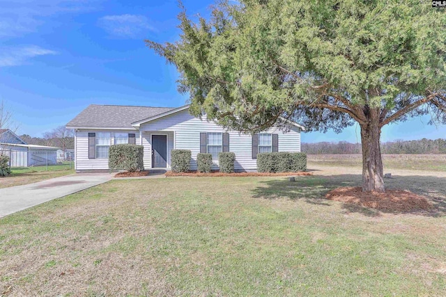 single story home featuring a shingled roof and a front lawn