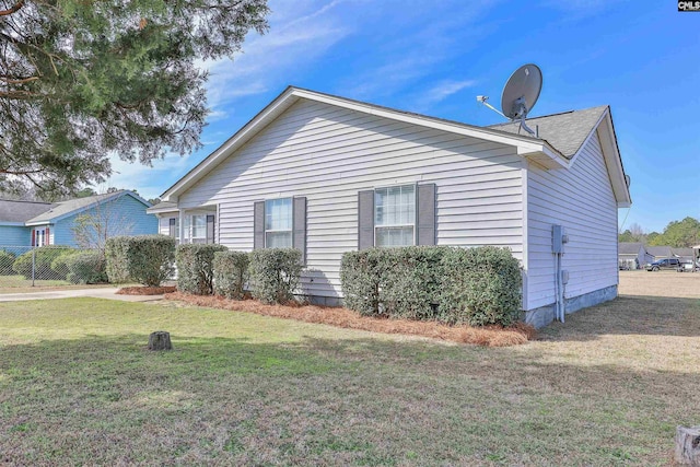 view of side of home with a yard