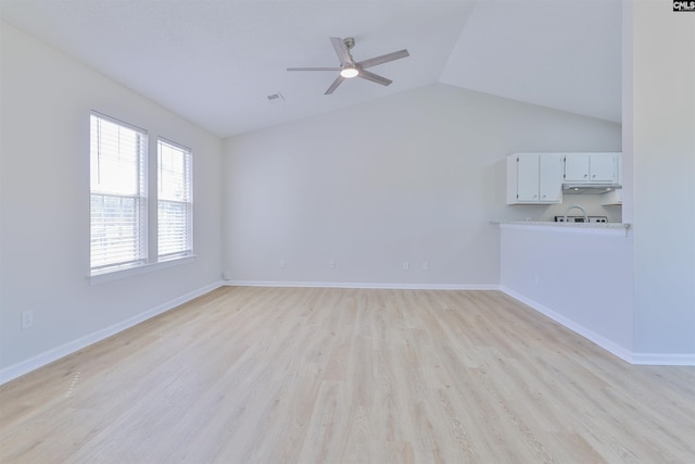 unfurnished living room with light wood-type flooring, baseboards, ceiling fan, and vaulted ceiling