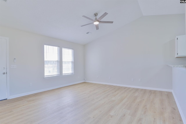 unfurnished room with lofted ceiling, light wood-style flooring, baseboards, and ceiling fan